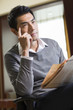 © Blue Jean Images - Young businessman reading newspaper in study