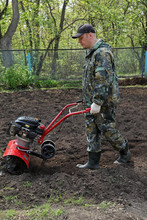 Man Working In The Garden Preparing Ground Cultivator
