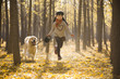 © Blue Jean Images - Little girl running with dog in autumn woods