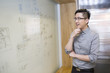 © Blue Jean Images - Businessman thinking in front of the whiteboard