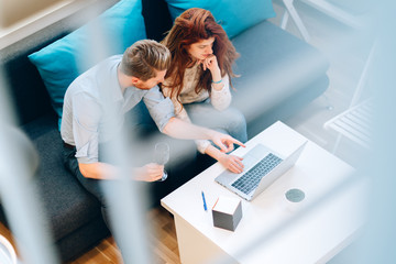 Couple browsing web together in living room