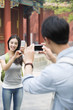 © Blue Jean Images - Young couple taking pictures with smart phones in the Lama Temple