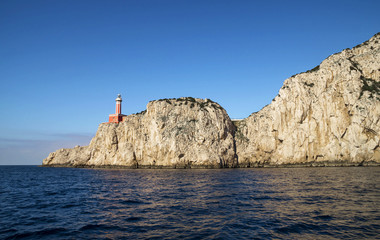 Poster - Punta Carena Lighthouse on the coastal rocks at the Mediterranean Sea in Capri island, seen from a motor boat tour.