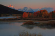 Oxbow Sunrise - A fog lifts from the Snake River as the first rays of sun light the peaks of the Grand Teton mountains.