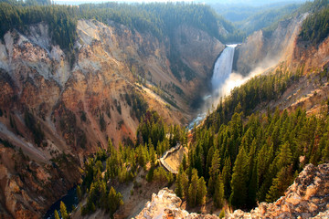 lower falls - sunlight illuminates the spray as the yellowstone river crashes over the lower falls i