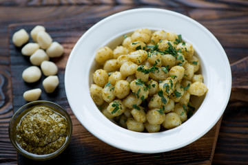 Wall Mural - Glass plate of gnocchi with pesto sauce, selective focus