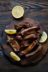 Wall Mural - Baked pork ribs with lemon, rustic wooden background, above view