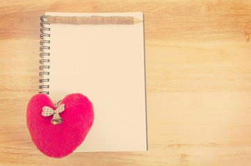 notebook with heart on wooden background