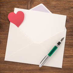 Wall Mural - White envelope with heart and a pen

