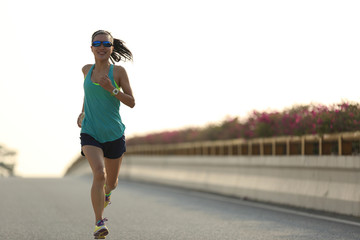 Poster - young woman runner running on city bridge road