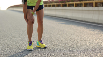 Sticker - woman runner hold her injured leg on road