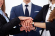 © rogerphoto - Business people group joining hands and representing concept of friendship and teamwork