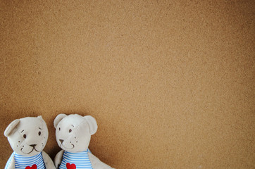 two teddy bear with heart on cork board background