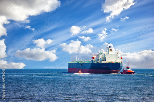 Fotografia Tanker ship with escorting tugs leaving port.
