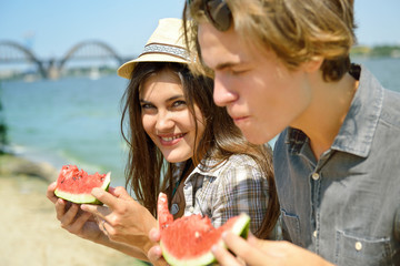 happy young couple eating watermelon on the beach. youth lifesty