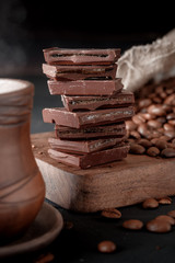 Wall Mural - Fresh roasted coffee beans and stack of brown chocolate.