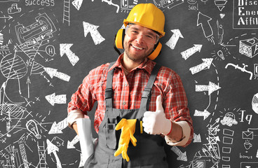 Wall Mural - Builder in yellow helmet, protective glasses and working clothes