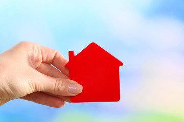 Sticker - Female hand holding model of house on bright background