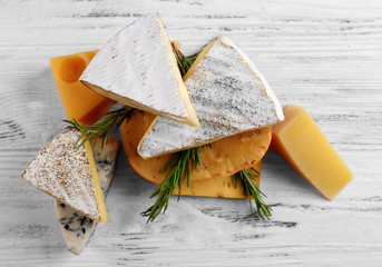 Wall Mural - Different kinds of cheese on white wooden background, close up