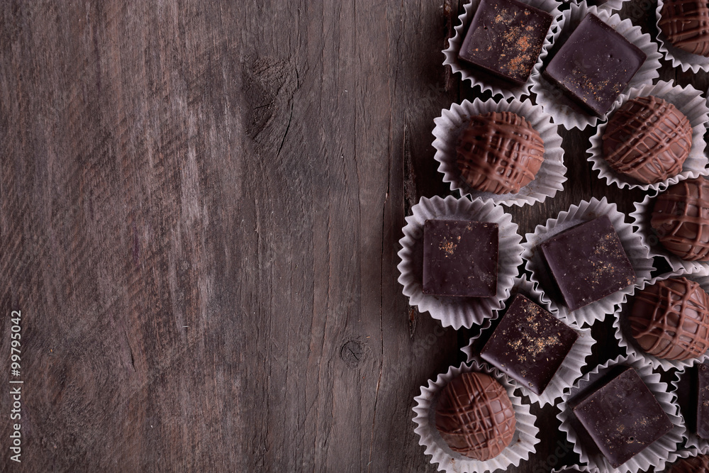 Assorted chocolate candies on wooden background
