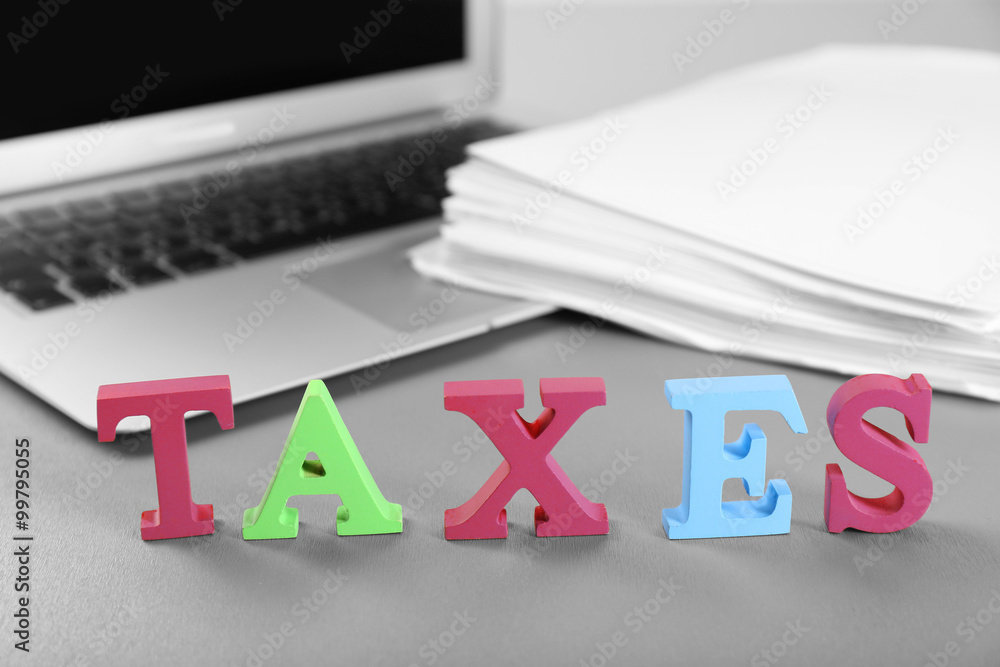 Alphabet TAXES and laptop on table
