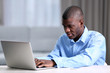 © Africa Studio - African American businessman in blue shirt with laptop, close up