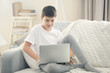 © Africa Studio - Boy using laptop on a sofa at home