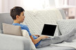 © Africa Studio - Boy with laptop sitting on a sofa