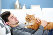© Africa Studio - Young man with fluffy cat lying on a sofa