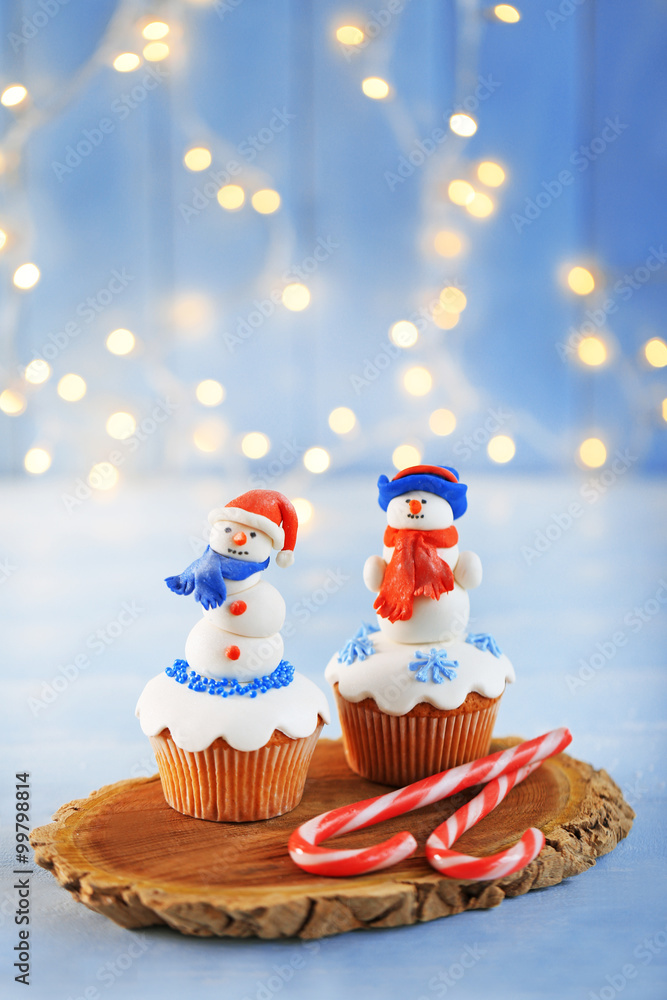 Christmas cupcakes with candies on wooden stand, closeup