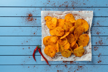 Sticker - Crispy potato chips on blue wooden table