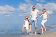 © altanaka - Father and children playing on the beach at the day time.