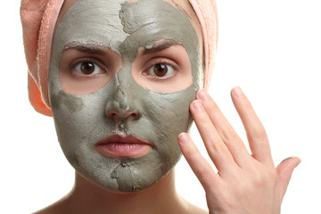 the mask of healing clay on the face of woman on white isolated background