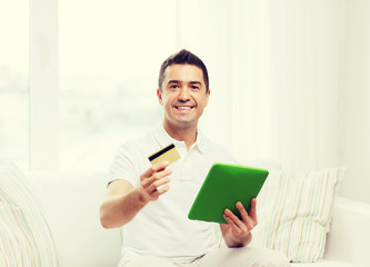 Poster - smiling man working with tablet pc at home