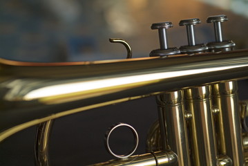 Three musical keys on a shiny trumpet.