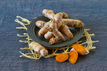 Wall Mural - Turmeric root and slices on wooden background