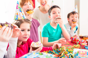 Wall Mural - Children at birthday party with muffins and cake