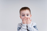 Fototapeta  - mały chłopiec trzyma dłonie przy twarzy 