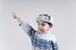 chłopak w zimowej czapce wykonuje gest dłonią 