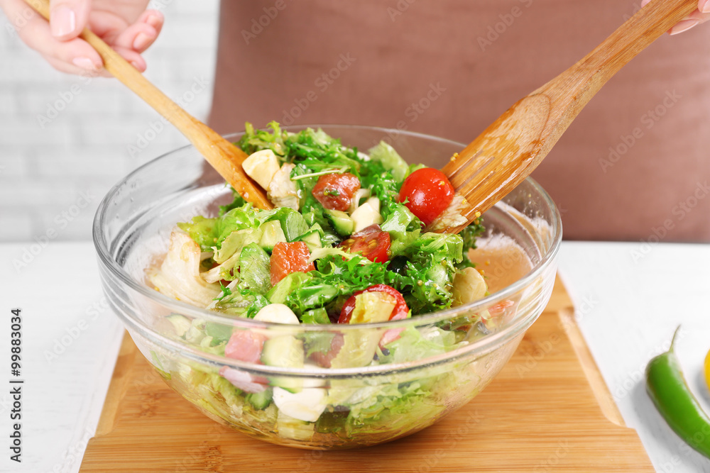 Young man preparing healthy salad, close-up