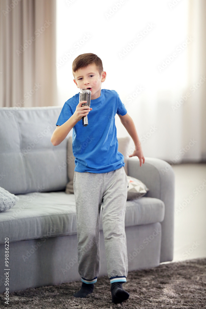 Little boy singing with microphone  at home