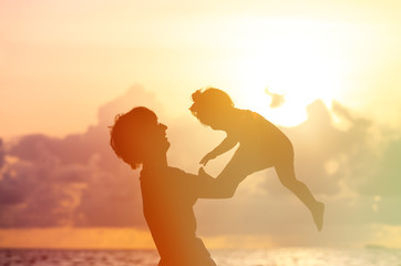 Wall Mural - Father and little daughter silhouettes at sunset