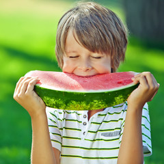 A boy are eating watermelon in nature 