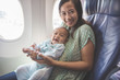 © Odua Images - mother and baby sitting together in airplane