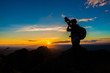 © themorningglory - Photographer man on mountain reaches for the sun