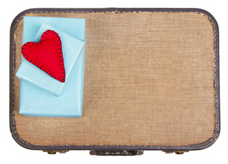 Handmade felt hearts sitting on presents on top of a suitcase