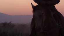 Close Up Shot Of Cowboys And Horses In The Sunset. Slow Motion