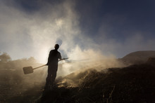 Silhouette Of Coal Man Working At Sunset In Smoke