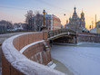 Saint Petersburg in winter at sunset. Malo-Konyushenny Bridge across the Moika River, the Cathedral of the Resurrection (Savior on Spilled Blood) and the building of the Higher School of Folk Arts