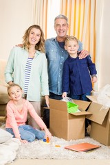 Wall Mural - Portrait of happy family opening boxes